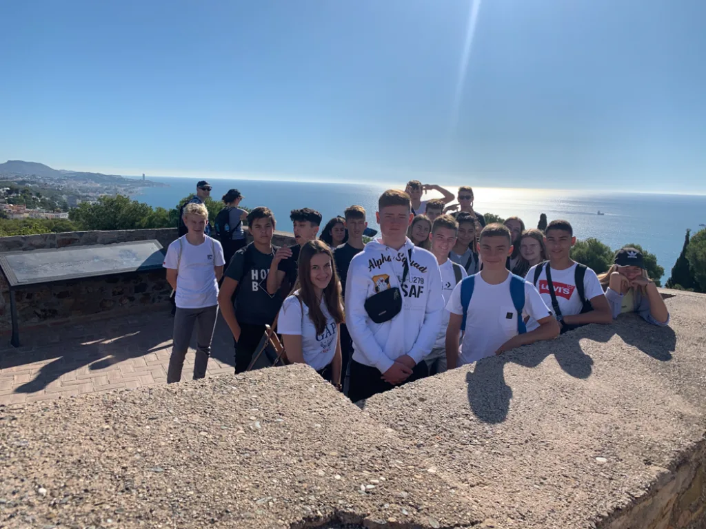 Gruppenfoto auf einer Festungsmauer über dem Meer bei Gegenlicht.